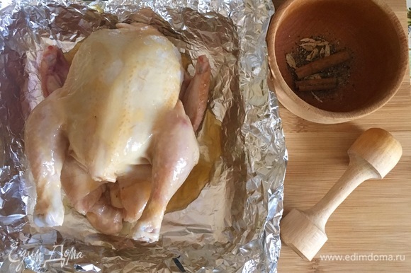 Половину порции корицы, бадьяна, измельченного кардамона и щепотку черного перца уложить внутрь курицы.