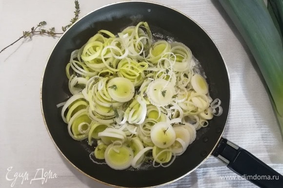 В сковороде разогреть по 1 ст. л. оливкового и сливочного масел. Выложить нарезанный тонкими кольцами порей, листья тимьяна.