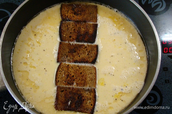 В глубокой сковороде разогреть оставшееся растительное масло, добавить сливочное и вылить взбитые с молоком яйца. По серединке уложить чесночные гренки.