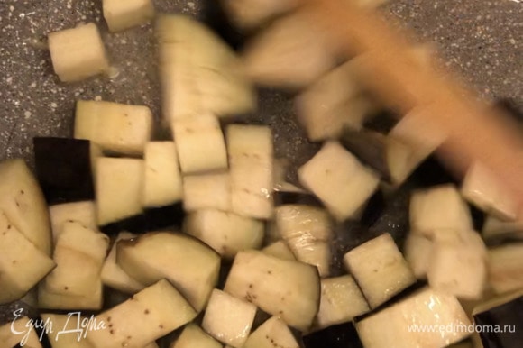 Нарезать кубиком баклажан. Разогреть сковороду с оливковым маслом, обжарить чеснок. Затем добавить баклажан и тушить почти до готовности баклажана.