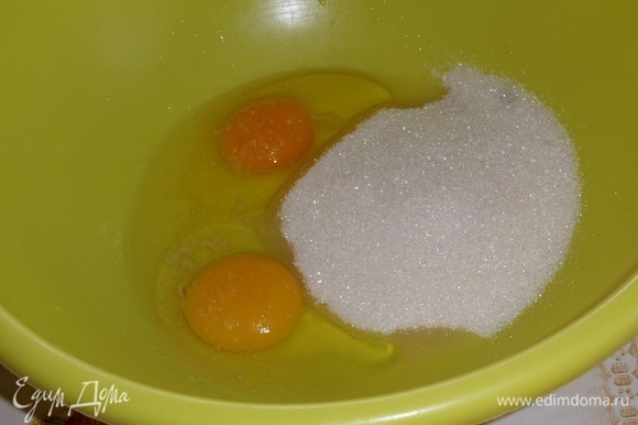 В другую чашку выкладываем куриные яйца и сахар. Слегка взбиваем.