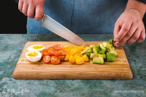Яйца отварите так, чтобы желток остался жидким, очистите от скорлупы. Яйца и помидоры черри разрежьте пополам, авокадо нарежьте небольшими кусочками.
