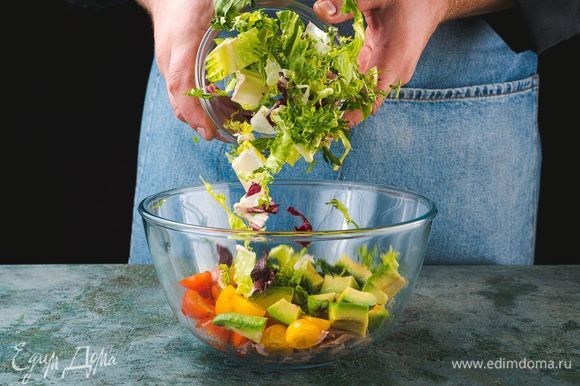 Добавьте в салатник нарезанные овощи и салатный микс.