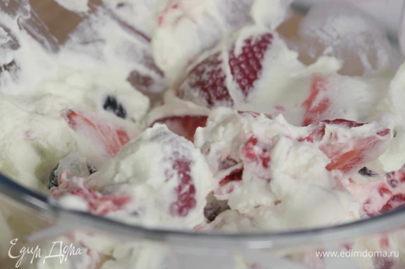 Крупные ягоды нарезать, выложить их все в одну миску, соединить со сливками и размешать, немного «приминая» ягоды. Отправить крем в холодильник.