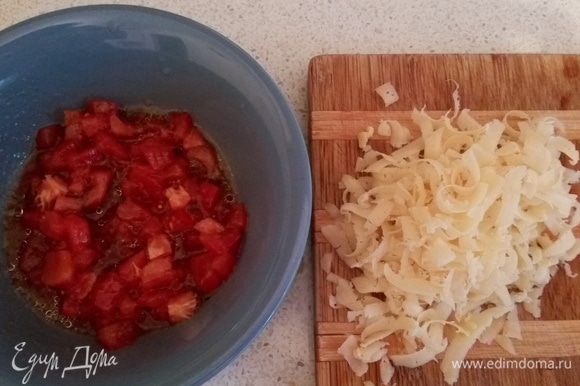 Пока готовятся баклажаны, нарежем помидор кубиком и добавим по 1 ст. л. соевого соуса и подсолнечного масла, а также натрем сыр на крупной терке.