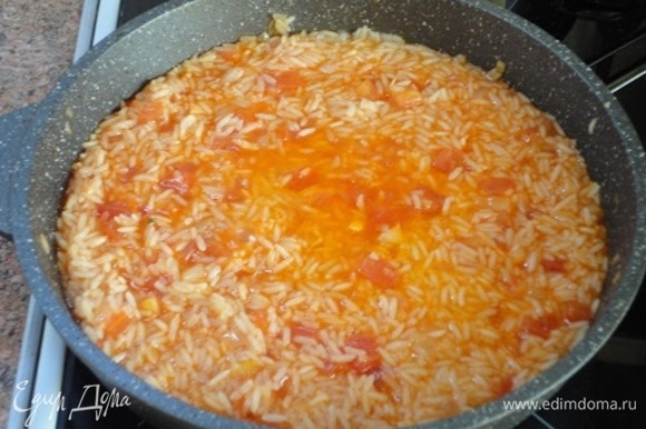 Добавить томатную пасту, влить овощной (или куриный) бульон, посолить и варить под крышкой на медленном огне до готовности риса (20–30 минут).