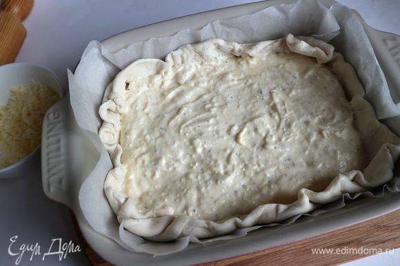 Поместить на тесто равномерно сырную смесь и часть натертого на крупной терке сыра (примерно половину).