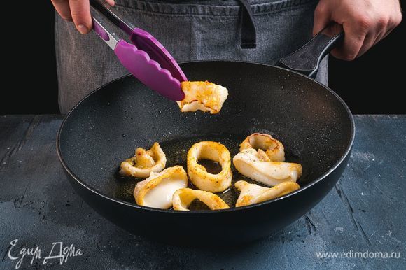 Выложите кальмары на раскаленную сковородку и обжарьте в масле до золотистой корочки.