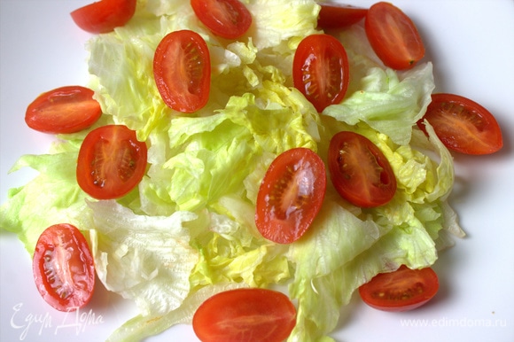 На тарелку порвать листья салата. Сверху кладем помидоры черри.
