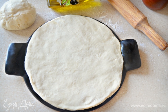 Духовку включите на 210–220°C. Форму для пиццы немного смажьте оливковым маслом (я использую специальную форму для пиццы, d=26 см) и выложите на нее половину теста (у нас будет 2 пиццы), слегка обмять и придать форму круга. Накройте полотенцем и отставьте на 10 минут. Затем тесто необходимо смазать оливковым маслом.