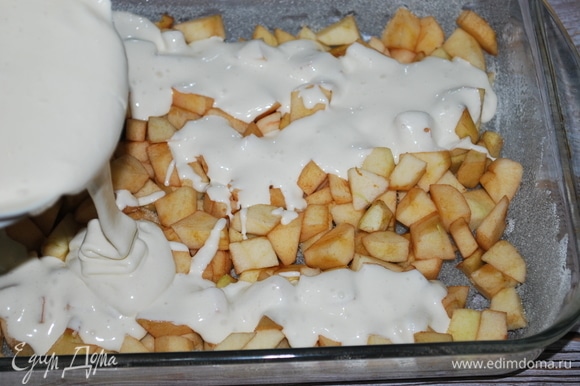Форму смажьте маслом, выложите нарезанные яблоки и сверху залейте тестом.