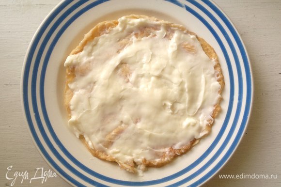 На сервировочную тарелку выложить яичный блинчик, намазать его 2 ст. л. плавленого сыра.
