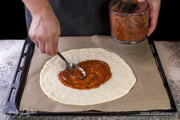Раскатайте тонкое тесто. Смажьте его поверхность томатным соусом.