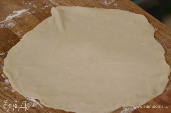 Рабочую поверхность присыпать оставшейся мукой и раскатать тесто в круглый пласт толщиной 2‒3 мм.