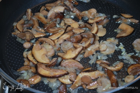 Обжарьте лук на сковороде пару минут и добавьте к луку грибы (у меня замороженные молодые подберезовики и белые грибы). Все вместе обжарьте в течение 5 минут.