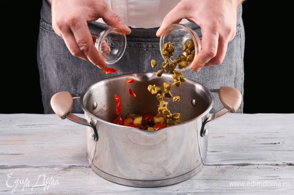 Вылейте получившийся соус в кастрюлю к баклажанам, туда же добавьте остальные овощи, каперсы, нарезанный перец чили.