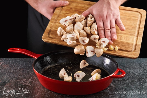 Сливочное и оливковое масла разогрейте в сковороде, выложите грибы и чеснок. Обжаривайте на сильном огне 3 минуты.