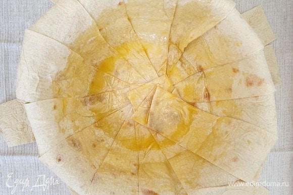 Тонкий лаваш нарезаем полосами шириной 6 см. Казан или толстостенную посуду для запекания хорошо смазываем сливочным маслом. Внахлест выкладываем полоски лаваша таким образом, чтобы края свисали. Смазываем лаваш сливочным маслом.