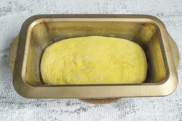 Обминаем тесто, посыпаем кукурузной мукой, формуем хлебушек подходящей формы, кладем в форму.