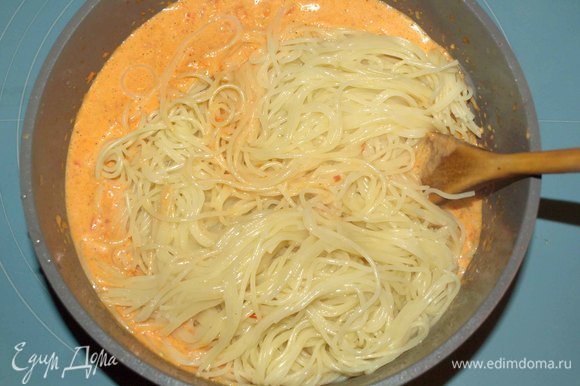 Перекладываем в соус приготовленные спагетти. Перемешиваем. Ставим на огонь и прогреваем 1–2 минуты.