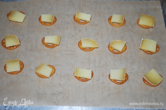 Сверху на крендель положите кусочек сыра. И поставьте в разогретую духовку примерно на 5 минут, сыр должен хорошо расплавиться.