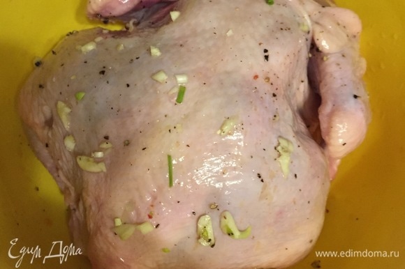 Сделать в курице надрезы и нашпиговать ее чесноком. Накрыть курицу пленкой и оставить в холодильнике мариноваться (в идеале на ночь).