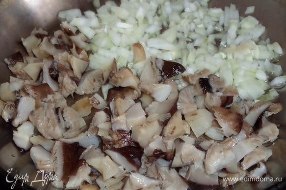 В разогретую сковороду наливаем растительное масло. Выкладываем нарезанные лук и грибы.