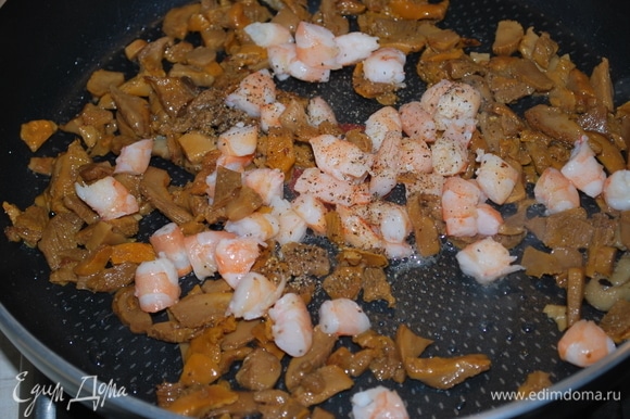 Грибы обжарьте на масле в течение 6–7 минут. Добавьте нарезанные креветки и обжарьте все вместе еще пару минут. Добавьте черный молотый перец по вкусу.