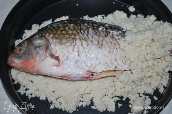 Выложите часть соляной смеси и на нее положите рыбу (я это сделала в чаше для микроволновой печи). Накройте сверху оставшейся смесью и обомните, чтобы она плотно прилегала к рыбе.