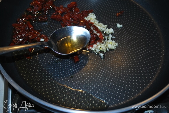 На оливковом масле обжарьте в течение 1–2 минут щепотку сухого базилика, чеснок и вяленые помидоры, нарезанные кусочками.