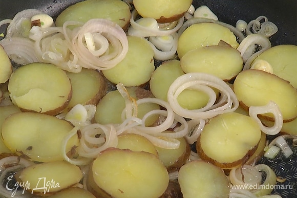 Разогреть в сковороде растительное масло и обжарить лук и чеснок до слегка золотистого цвета, затем добавить нарезанный картофель и немного обжарить.