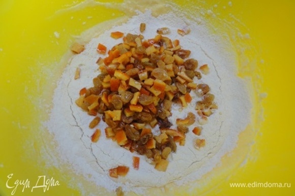 К яично-масляной массе добавить цедру апельсина, аккуратно просеять сухую смесь, а также цукаты и изюм.