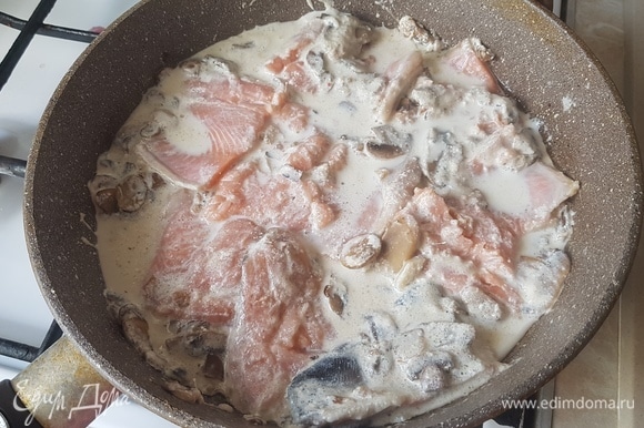 В сливочно-грибной соус выложить рыбу, накрыть сковороду крышкой и тушить 20 минут на медленном огне.