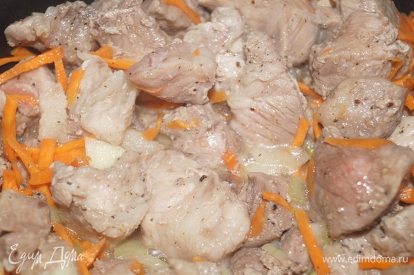 Добавьте к мясу лук, морковь, соль, специи. Перемешайте и жарьте на той же функции еще 15 минут при закрытой крышке, пару раз перемешайте, чтобы не пригорело.