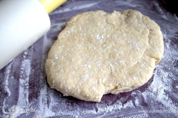 Раскатать липкое тесто на поверхности с мукой.