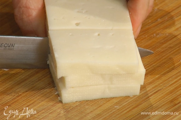 Сыр нарезать крупными ломтиками толщиной 1/2 см, затем разрезать их пополам.