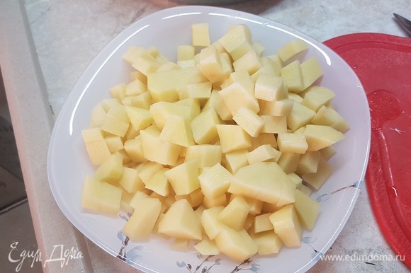 Картофель нарезать небольшим кубиком. Выложить в бульон картофель, лук и морковь. Варить до готовности картофеля.