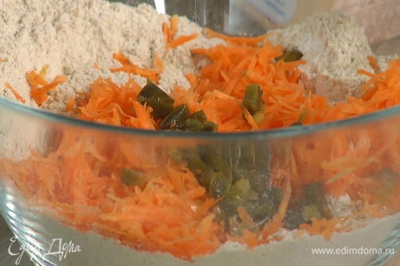 В глубокой миске соединить всю муку, разрыхлитель, соду и соль, затем добавить натертую морковь, перец халапеньо, шалот и шпинат, все перемешать.