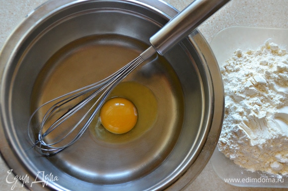 Далее займемся тестом. В емкости для замешивания взбейте яйцо, добавьте пару щепоток соли, влейте 200 мл теплой воды, перемешайте. Затем постепенно добавляйте муку. Муки может уйти чуть больше или меньше, чем указано в рецепте. Готовое тесто должно быть достаточно упругим, но эластичным. Соберите его в шар, накройте полотенцем и дайте отдохнуть 20 минут. Перед тем как начнете с ним работать, еще раз вымешайте.