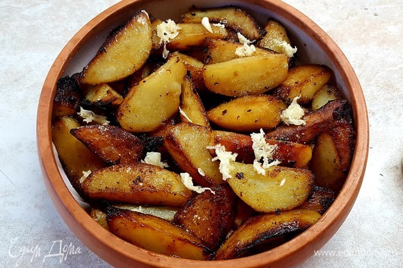 На индейку выложить картофель и тоже посыпать чесноком и специями с солью.