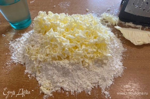 Замороженное сливочное масло (можно заменить маргарином) натереть на крупной терке, соединить с мукой и порубить ножом.