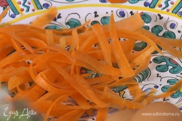 Морковь почистить и нарезать овощечисткой тонкими полосками.