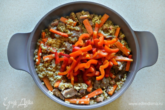 В сотейник добавьте морковь, тушите блюдо в течение 7 мин. Далее добавьте перец и тушите еще в течение 5 мин.