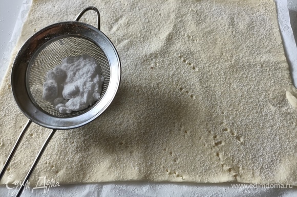 Слоеное тесто немного раскатать, разрезать пополам, наколоть вилкой, посыпать сахарной пудрой и выпекать в разогретой до 180°C духовке в течение 10–15 минут.