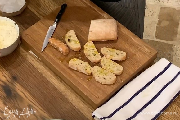 Хлеб нарезать ломтиками, сбрызнуть с двух сторон оставшимся оливковым маслом и обжарить на сухой сковороде-гриль.
