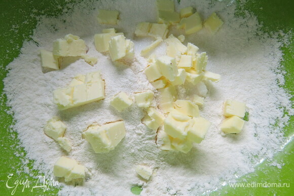 Готовим тесто. В миску просеиваем муку, добавляем соль и сахар. Сюда же рубим кубиками холодное сливочное масло и быстро перетираем его с мукой.