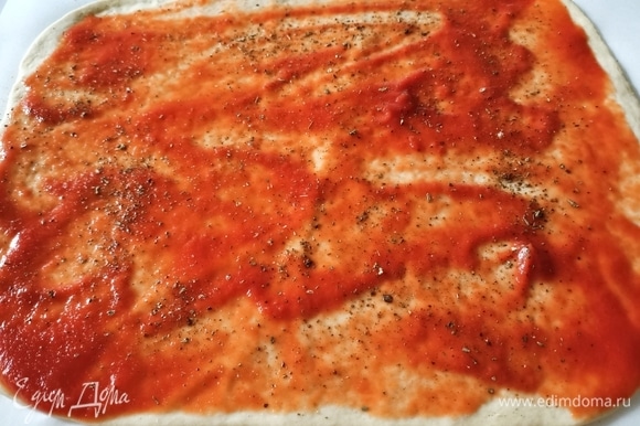 Полить оливковым маслом, смазать томатным пюре и посыпать приправой для пиццы.