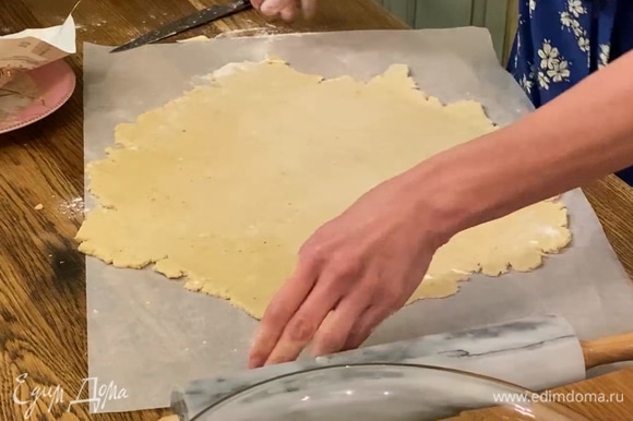 Выложить тесто на лист бумаги для выпечки и раскатать в тонкий корж.