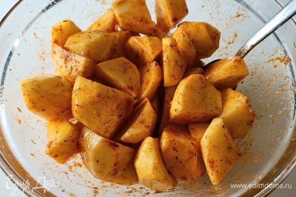 Картофель нарезать небольшими кусочками. Добавить соль, паприку, перец, розмарин и оливковое масло. Перемешать.