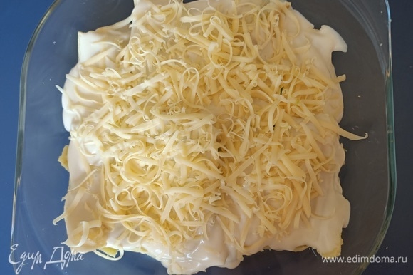 Блинчики выложить в форму для запекания, каждый получившийся слой полить соусом и посыпать сыром.